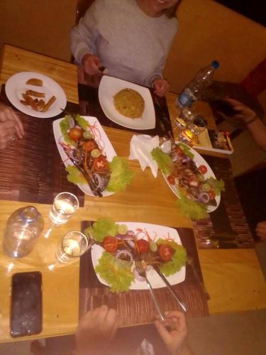 a group of people sitting at a table with plates of food at Dolphin Village in Kalpitiya