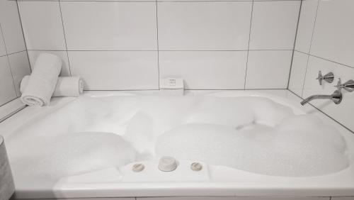 a bath tub with a faucet and a sink at City Reach Motel in Wangaratta