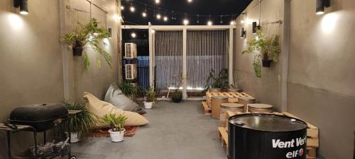 a room with tables and potted plants and lights at Little One in Chiang Rai