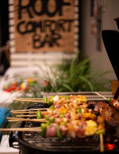 a grill with meat and vegetables on it with chopsticks at Little One in Chiang Rai