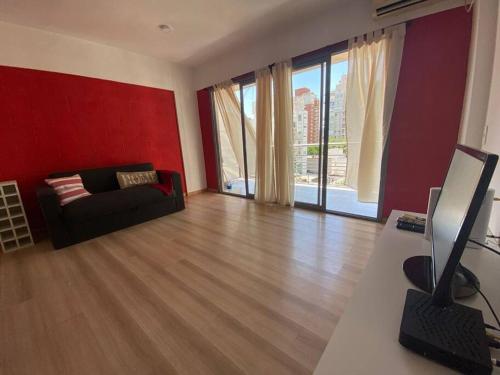 sala de estar con sofá negro y pared roja en Departamento en Caballito en Buenos Aires