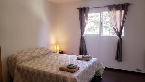 1 dormitorio con 1 cama con 2 toallas en Lajas Del Sur en Ushuaia