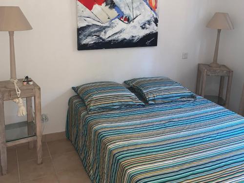 une chambre avec un lit et un tableau au mur dans l'établissement Appartement climatisé à Collioure : Terrasse, Wi-Fi, Piscine chauffée, Parking privé. - FR-1-309-143, à Collioure
