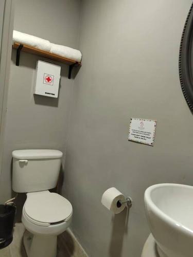 a white bathroom with a toilet and a sink at 10th ave Suite in Cozumel