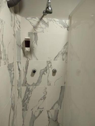 a bathroom with a shower with a marble wall at 10th ave Suite in Cozumel