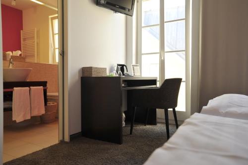 a bedroom with a desk and a bed and a mirror at Maximilian in Speyer