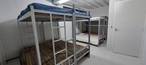 two bunk beds in a room with a door at CHÁCARA Na Represa in Ibiúna
