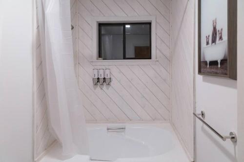 a white bathroom with a shower with a window at Pocono Mountain Dream House near Camelback in Tobyhanna