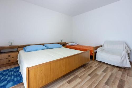 a bedroom with a bed and a chair at Apartment Kreso in Punat