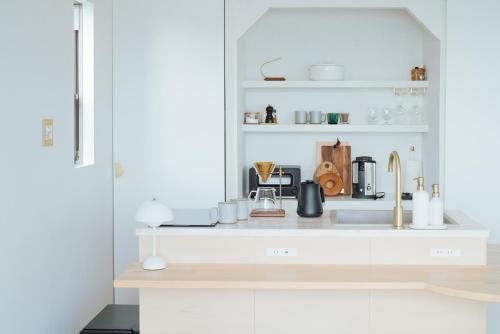 a white kitchen with a sink and a counter top at HOLLY CAMP CASA in Akagina