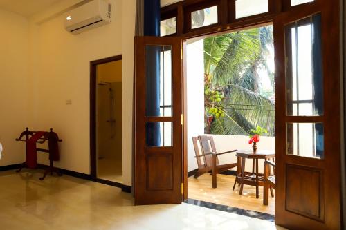 una puerta abierta a una habitación con una mesa en Tropical Inn, en Mirissa