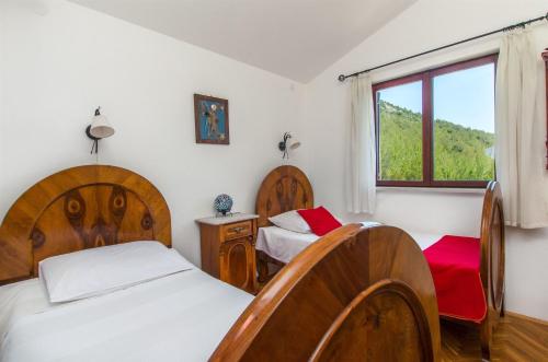 a bedroom with two beds and a window at Apartments Ana in Blato