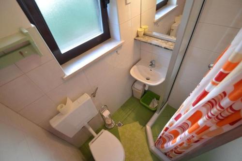 a small bathroom with a toilet and a sink at Apartments Nevenka in Mali Lošinj