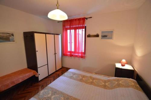 a bedroom with two beds and a red window at Apartments Nevenka in Mali Lošinj