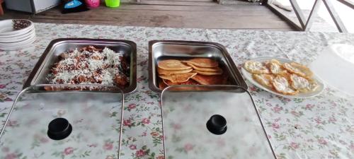 a table with two trays of food on a table at Gibran guest house in Kri