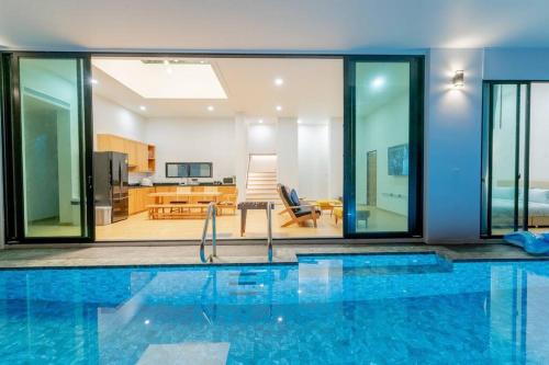 a house with a swimming pool and a living room at สุขใจพูลวิลลาหัวหิน วิลลาส่วนตัววิวทะเลใจกลางเมือง in Hua Hin