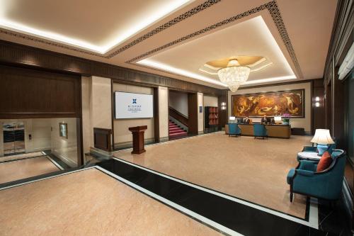 a lobby of a hotel with a television and chairs at Xiamen C&D Hotel-Free Welcome Snacks-Oasis Garden in Xiamen