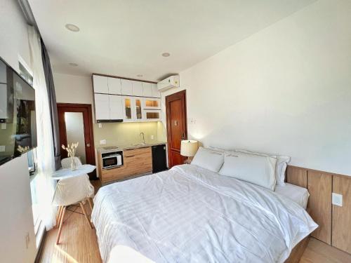 een slaapkamer met een wit bed en een keuken bij Rivesride house Quận Phú Nhuận 3 in Ho Chi Minh-stad