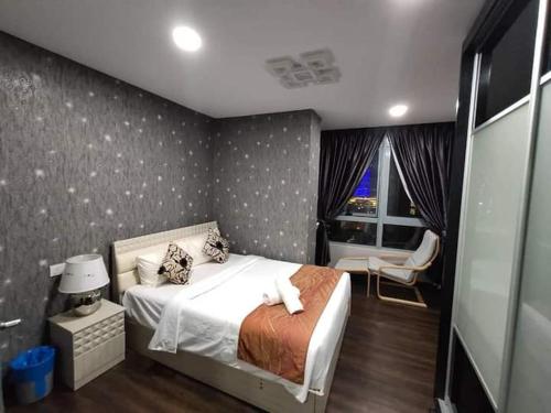 a bedroom with a bed and a chair and a window at Taragon Time Service Suite in Kuala Lumpur