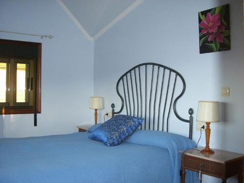 a bedroom with a blue bed with a blue pillow at House - 3 Bedrooms with WiFi - 00075 in Bueu