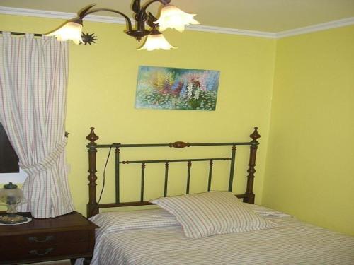 ブエウにあるHouse - 2 Bedrooms with WiFi - 00117のベッドルーム1室(ベッド1台付)が備わります。壁に絵が飾られています。