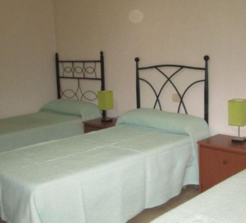 a bedroom with two beds with white sheets and lamps at Apartment - 2 Bedrooms with WiFi and Sea views - 01893 in Bueu