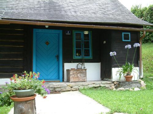 a house with a blue door and some flowers at Bachkeusche in Ossiach