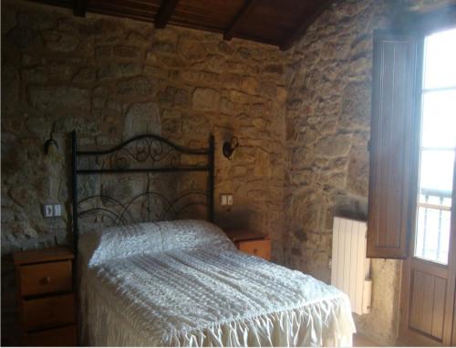 a bedroom with a bed in a stone wall at House - 2 Bedrooms - 03474 in Viseo