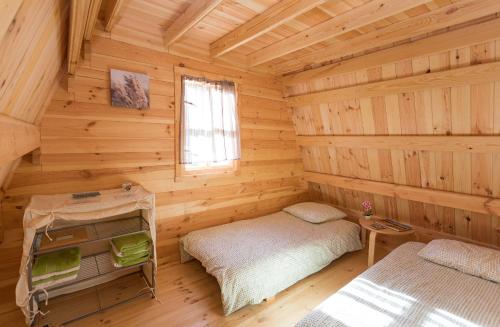 une chambre avec deux lits dans une cabane en rondins dans l'établissement Ferme Rony Camp des Découvreurs, à Saint-Nizier-du-Moucherotte