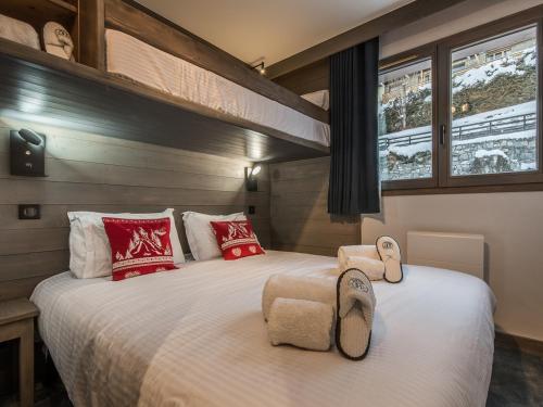 - une chambre avec 2 lits dotés d'oreillers rouges et blancs dans l'établissement Superbe appartement à Méribel avec garage privatif et balcon - FR-1-613-12, à Méribel