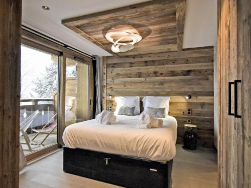 - une chambre avec un lit et un mur en bois dans l'établissement Appartement Méribel, 4 pièces, 7 personnes - FR-1-613-54, à Les Allues