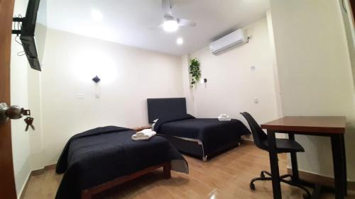 a bedroom with a bed and a desk and a chair at Gran Imperial Avenida in Tumbes