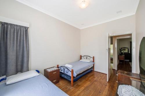 ein kleines Zimmer mit zwei Betten und einem Fenster in der Unterkunft Busselton River Cottage with WiFi in Busselton