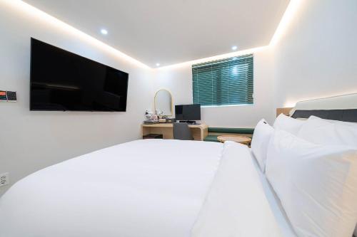a bedroom with a large bed and a tv at Browndot Hotel Namchuncheon in Chuncheon