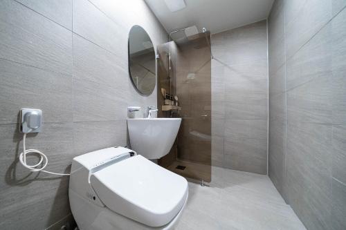 bagno con servizi igienici bianchi e specchio di Browndot Hotel Namchuncheon a Chuncheon