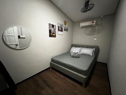 une petite chambre avec un lit et un miroir dans l'établissement BELLA COTTAGE, à Pantai Cenang
