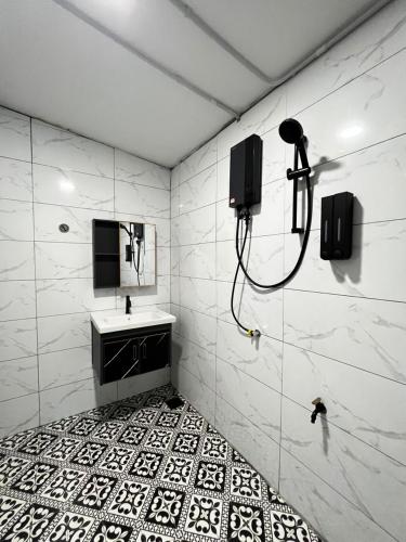 a bathroom with a shower and a sink and a mirror at BELLA COTTAGE in Pantai Cenang