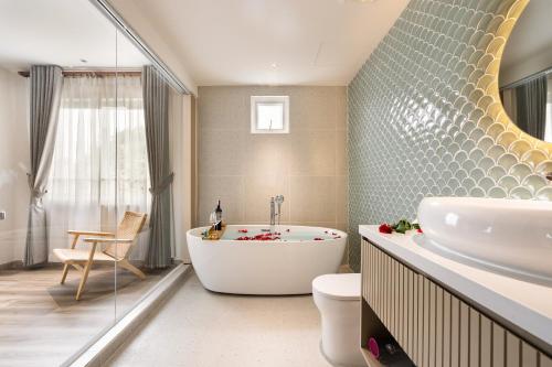 ein Badezimmer mit einer Badewanne, einem WC und einem Waschbecken in der Unterkunft Jovia Hotel in Ho-Chi-Minh-Stadt