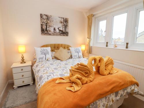 a bedroom with a bed with towels on it at Rosemary Cottage in Bourton on the Water