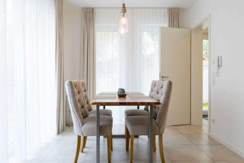 een eetkamer met een houten tafel en stoelen bij Gartenhaus am Waldschloss App 1 in Heringsdorf