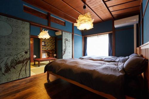 a bedroom with a large bed in a room with blue walls at EK House Kamakura 鎌倉 Free Parking in Kamakura