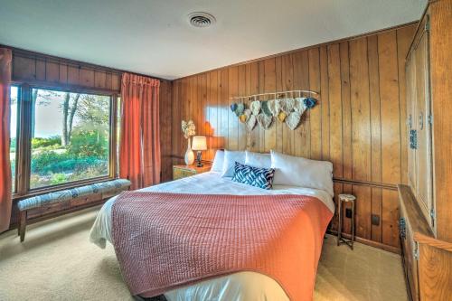 um quarto com uma cama com paredes de madeira e uma janela em Luxe Waterfront Haven Private Beach, Hot Tub em Benton Harbor