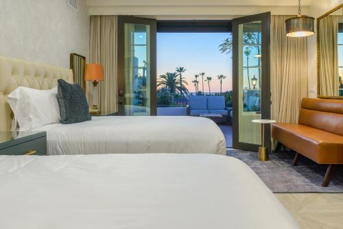 a hotel room with two beds and a balcony at North Beach Villa in San Clemente