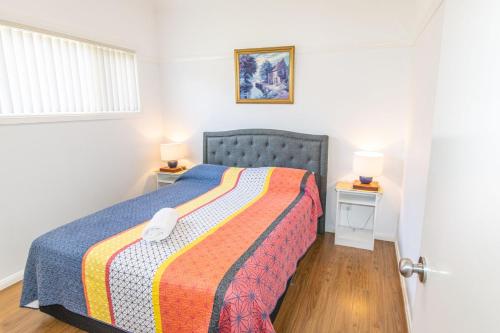 a bedroom with a bed with a colorful blanket at Cillanti in Sussex inlet