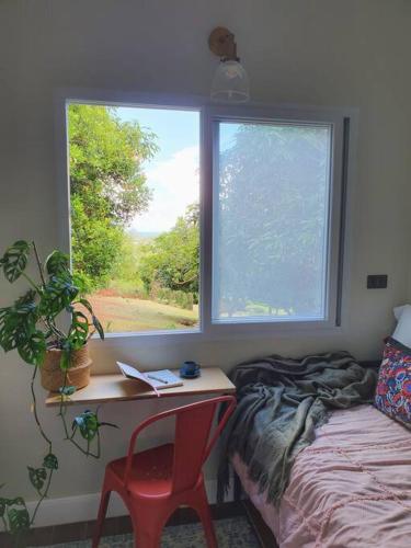 Schlafzimmer mit einem Schreibtisch, einem Bett und einem Fenster in der Unterkunft Swansea Hills Tiny Home in Puerto Princesa