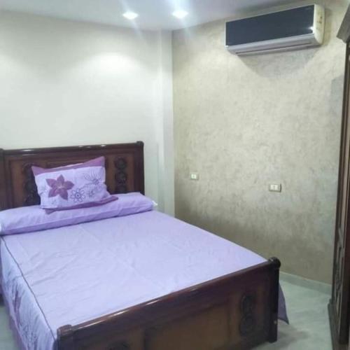 a bedroom with a bed with purple sheets and a fan at الاسكندريه المعموره الشاطئ in Alexandria