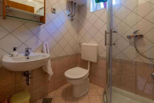 a bathroom with a toilet and a sink and a shower at Apartments Villa Katarina in Selce