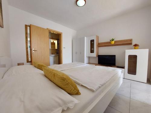 una grande camera da letto bianca con un grande letto di Apartments Jordanka a Crikvenica