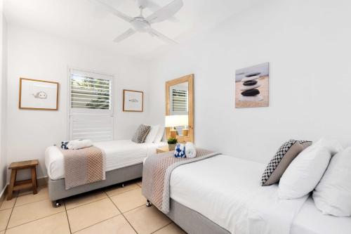 a bedroom with two beds and a window at Portofino 1 in Noosa Heads