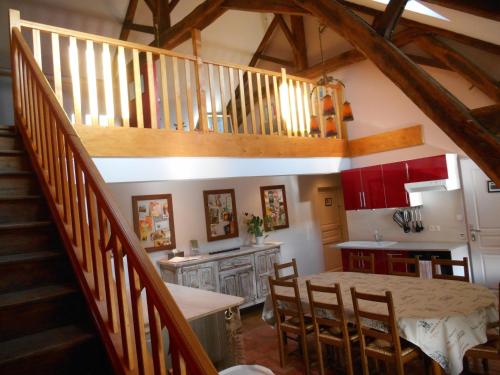 uma cozinha com uma escada e uma mesa com cadeiras em Escampette em Saint-Aubin-en-Charollais